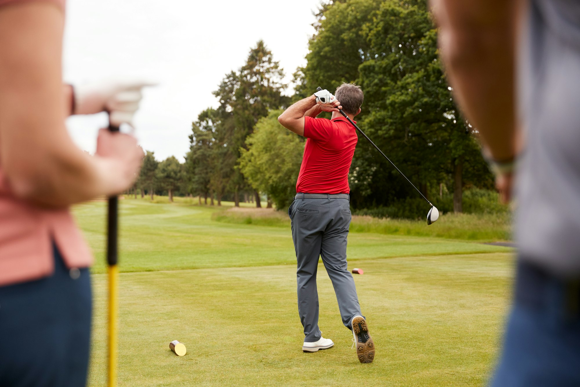 Golf Professional Demonstrating Tee Shot To Group Of Golfers During Lesson